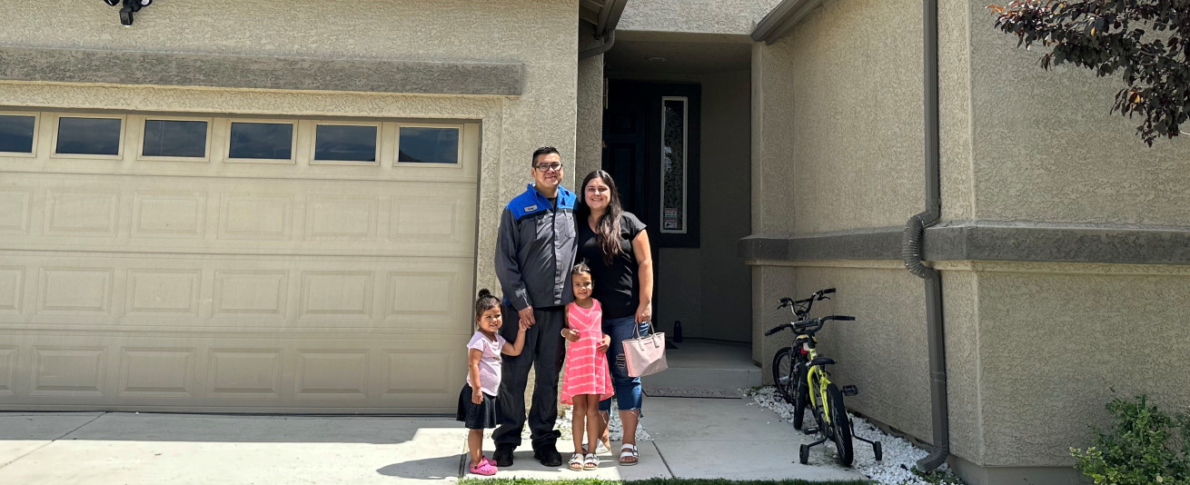 photo of Justina Yellowhair with her husband and two children in from of a home they purchased with a grant from FHLBank San Francisco